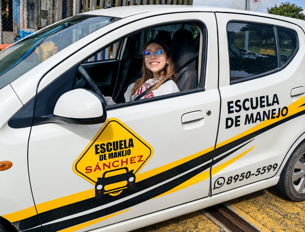 Dos estudiantes junto al vehículo de la escuela de manejo